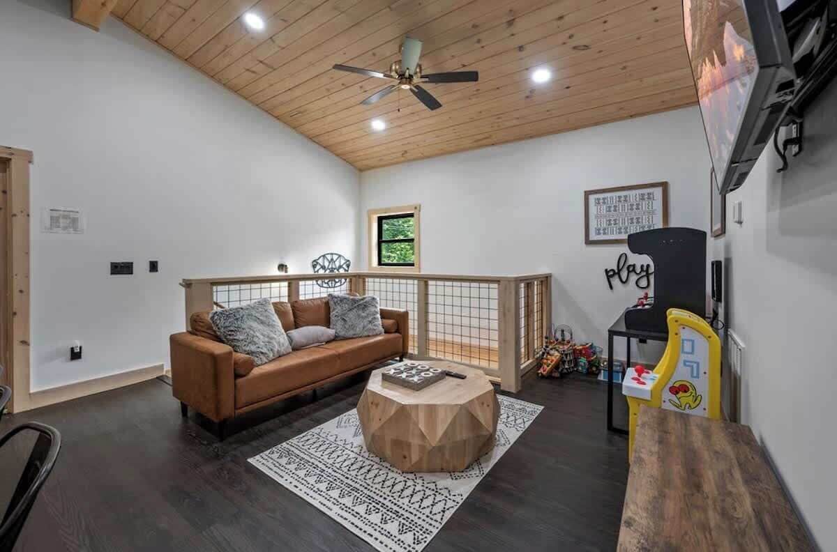 A cozy room with a brown sofa, a wooden coffee table, and a play area with toys.
