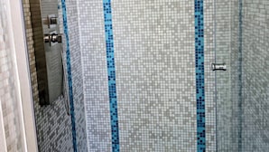 A tiled shower area with a blue and white mosaic pattern.