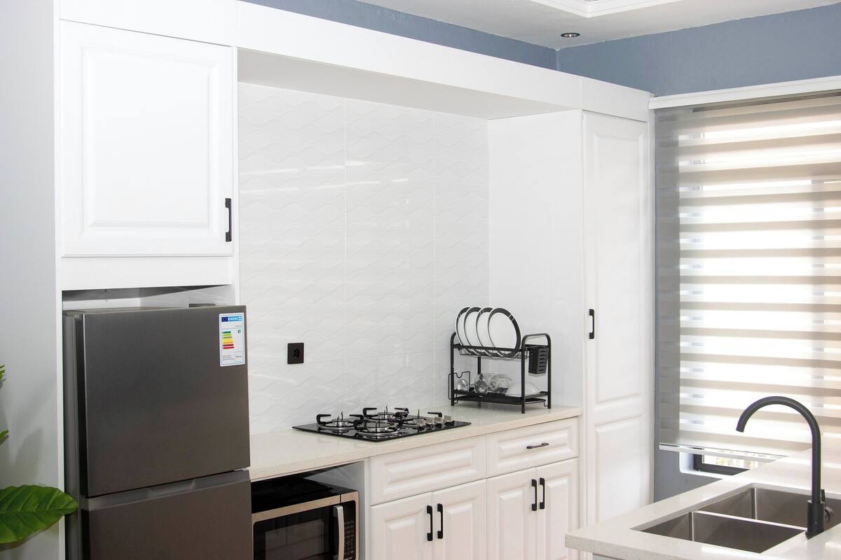 A kitchen with a refrigerator, stove, oven, and sink.