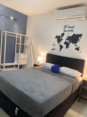A bedroom with a bed, a world map wall art, an air conditioner, and a ladder against the wall.