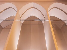 Un couloir doté de plafonds en arc de cercle et d’un luminaire central.