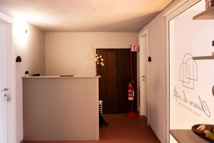 En hall med en receptionsdisk, en brandsläckare och en dörr med en skylt.