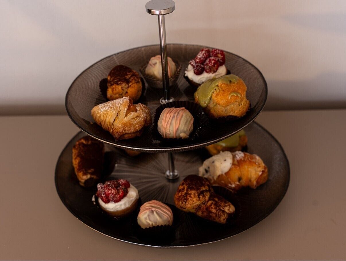 Een drielaags taartplateau met verschillende gebakjes en desserts.
