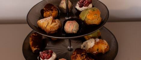 Een drielaags taartplateau met verschillende gebakjes en desserts.