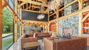 Un intérieur spacieux agrémenté d’une cheminée en pierre, de poutres en bois et d’un grand espace salon.