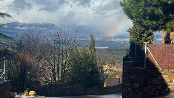 A stone building with a view of mountains and a rainbow.