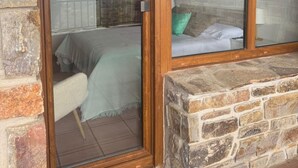 A room with a sliding glass door leading to a balcony with a bed and a view of the sky. - Apartment in Berzosa del Lozoya with beautiful views (Berzosa del Lozoya)