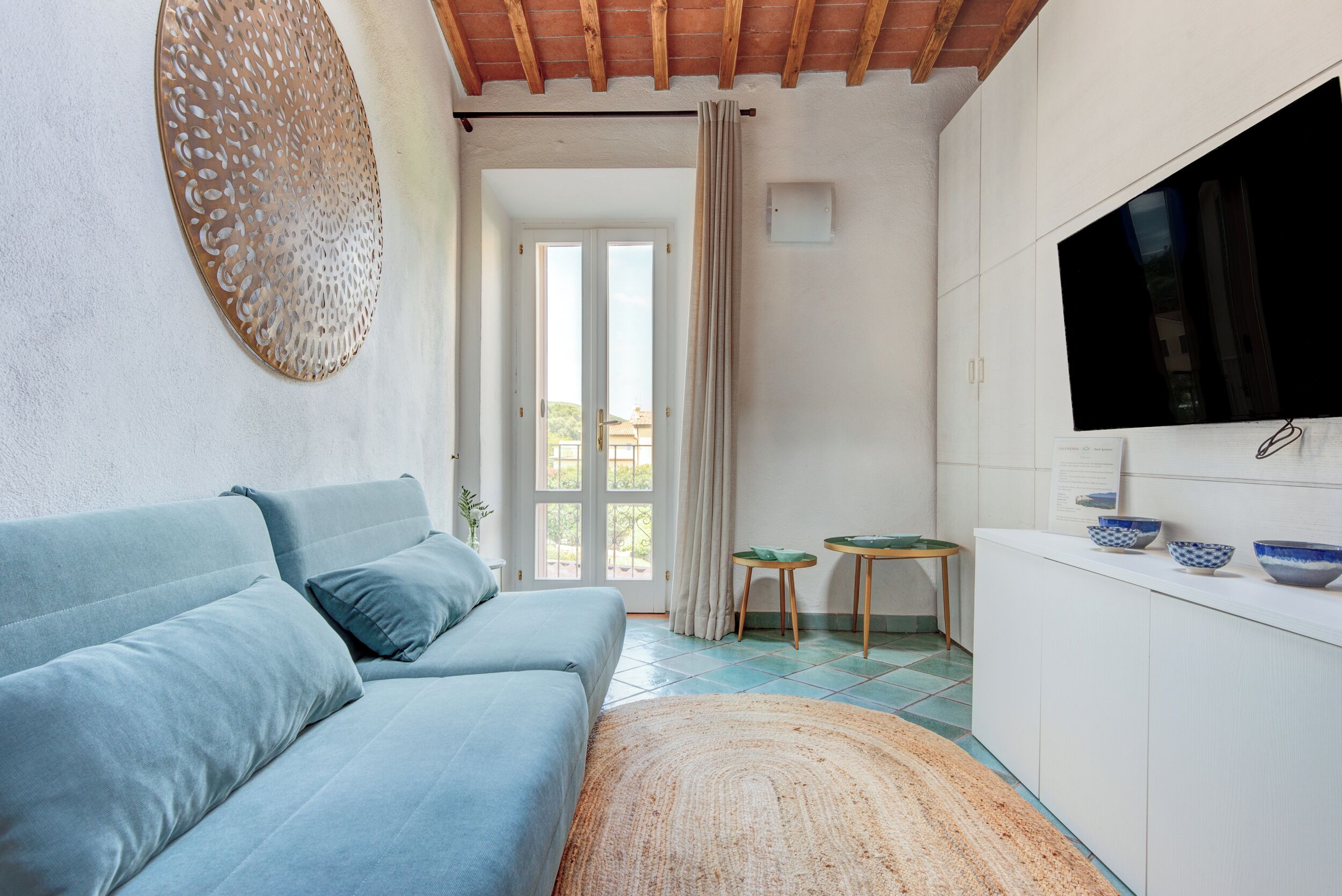 Un salon moderne comprenant un canapé, un téléviseur et un coin repas avec une table et des chaises.