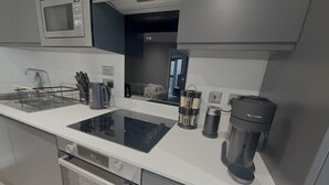 A modern kitchen with a built-in microwave, a coffee maker, and a kettle. - Albert Dock Luxury Penthouse – Walk to Liverpool ONE (Liverpool)