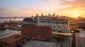 A cityscape with a mix of modern and older buildings, a river, and a sunset. - Albert Dock Luxury Penthouse – Walk to Liverpool ONE (Liverpool)