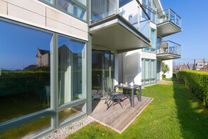 A modern house with large glass windows, a wooden deck, and a two-story balcony. - Karolva-St Ives-Ground Floor Apartment-Parking (St Ives)