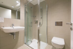 A modern bathroom with a glass-enclosed shower, a white sink, and a toilet. - Karolva-St Ives-Ground Floor Apartment-Parking (St Ives)