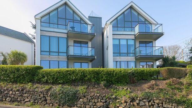A modern two-story building with large windows and balconies. - Karolva, St Ives - Ground Floor Apartment – On -Site Parking (St Ives)