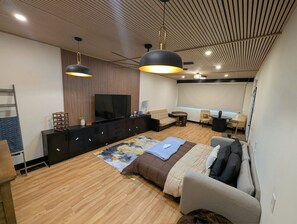 Uma sala de estar moderna com um sofá, uma mesa de centro, uma televisão e teto de madeira.