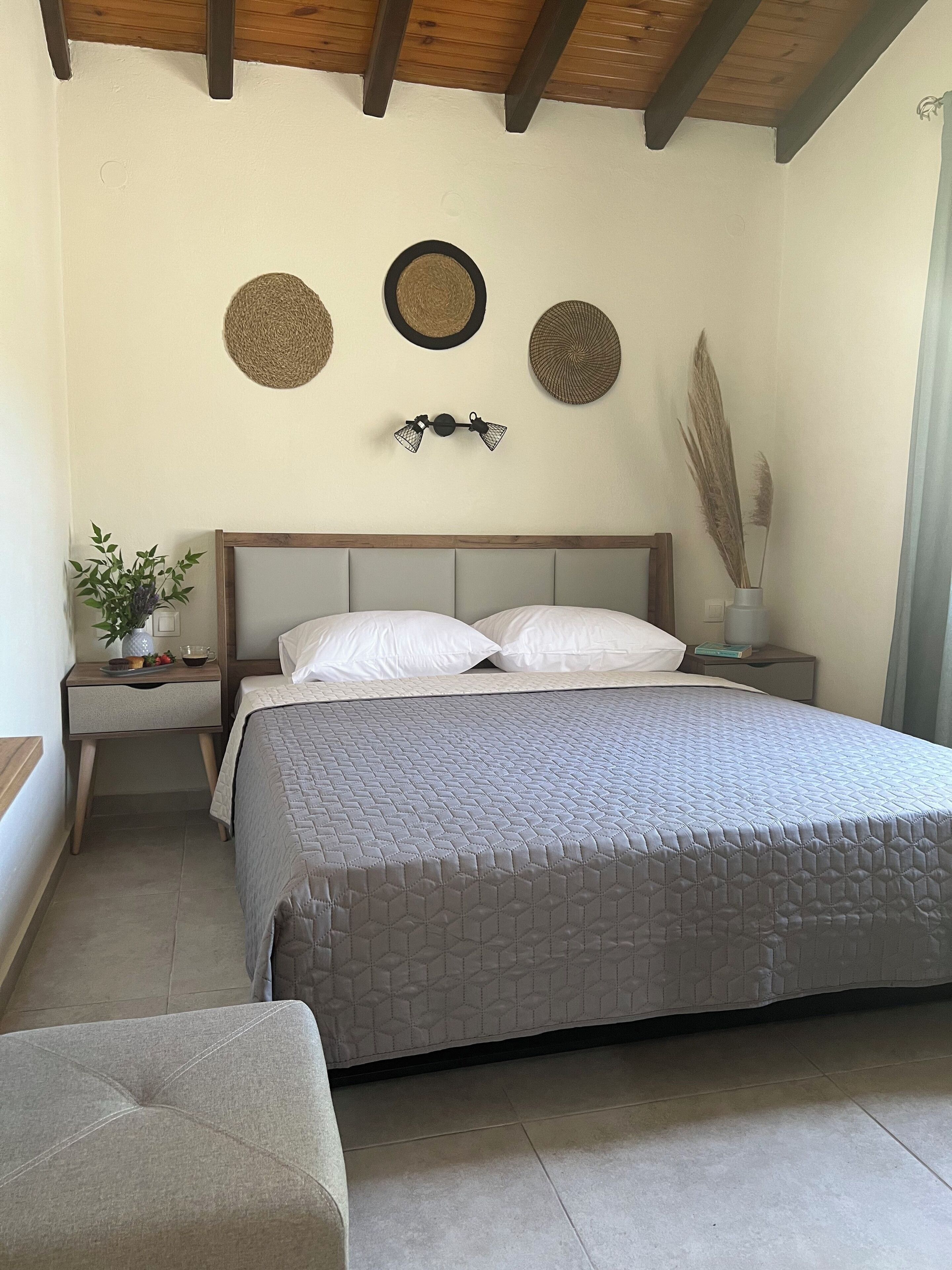 Ein Schlafzimmer mit Bett, Nachttischen, einer Wandlampe und einer Wanddekoration.