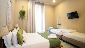 A hotel room with a bed, two single beds, a TV, a plant, and a window with curtains. - HOPESTEL Secret Garden Napoli (Naples)