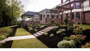 A large, two-story house with a brick exterior and a covered porch.