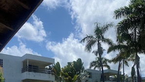 A swimming pool with lounge chairs and a view of a multi-story building.