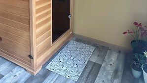 Een houten garderobe met een digitaal slot, een kamerkleed met dessin en een schilderij van een zeilboot aan de muur.