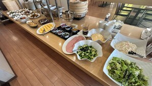 A buffet with various food items and a steam pot in the background. - Lasting Hotel (Kushiro)