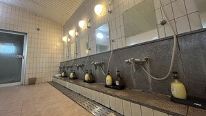 A public restroom with multiple sinks, hand dryers, and a tiled floor. - Lasting Hotel (Kushiro)