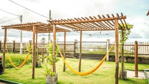 A wooden pergola structure with a hammock and potted plants. - Summerville #159 - House With Pool by Carpediem (Caucaia)