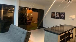 Un interior moderno con un sofá, una zona de bar y un comedor.
