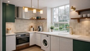Eine moderne Küche mit Einbauofen, Waschmaschine und Kaffeemaschine.