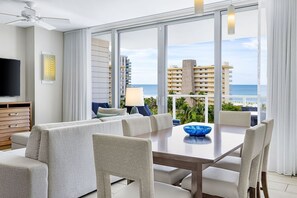 Een moderne hotelkamer met een groot balkon, een eethoek en een televisie.