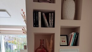 Een boekenplank met boeken, een vaas en een decoratief object.
