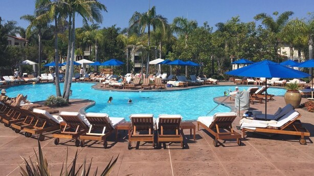 A pool area with lounge chairs and umbrellas. - Four Seasons Residence Aviara (Carlsbad)