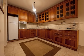 Une cuisine avec des meubles de rangement en bois, un réfrigérateur, un four et un four à micro-ondes.