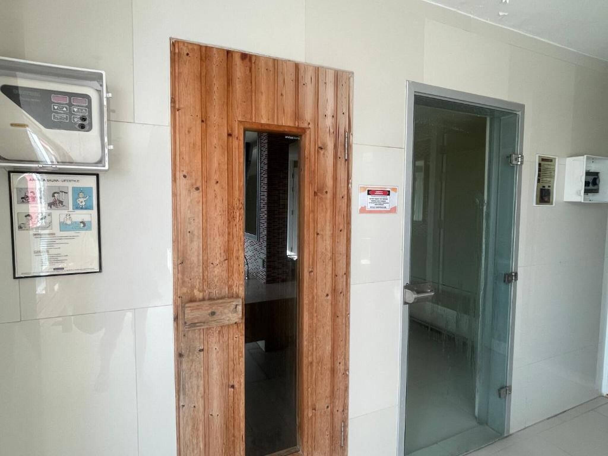 A hallway with a wooden door, a glass door, and a wall-mounted air conditioning unit.