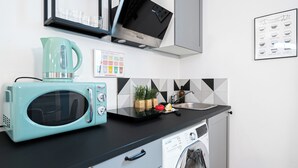 A modern kitchen with a teal microwave, a coffee maker, a sink, and a dishwasher. - Italianway Easy - Andrea del Sarto 32 (Milan)