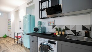 A modern kitchen with a washing machine, a microwave, and a coffee maker. - Italianway Easy - Andrea del Sarto 32 (Milan)