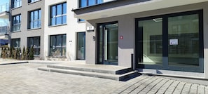 Un edificio moderno con amplios ventanales, una entrada visible y un cartel que indica una oficina de correos de policía.