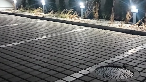 Ein gepflasterter Bereich mit einem Gebäude im Hintergrund.