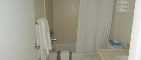 A bathroom with a bathtub, toilet, and sink.