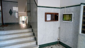 A marble staircase leading to a room with a bulletin board and a digital display. - Naif (Rome)