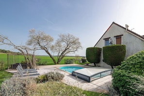 Une maison avec une piscine, un jardin et une vue sur la campagne.