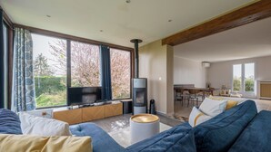A modern living room with a sofa, a television, and a fireplace.