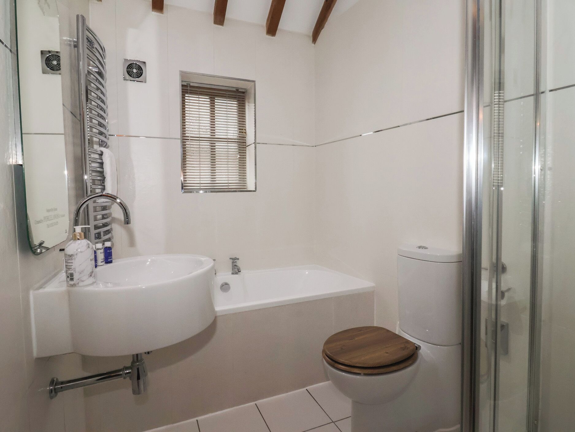 A bathroom with a white sink, a bathtub, a toilet, and a shower enclosure.