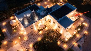 Eine Vogelperspektive eines Hotels mit Pool auf dem Dach, mehreren Restaurants und Außenbeleuchtung.