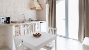 A kitchen with a white table, chairs, a sink, and a stove. - Apulian Charm STELLA (Martina Franca TA)