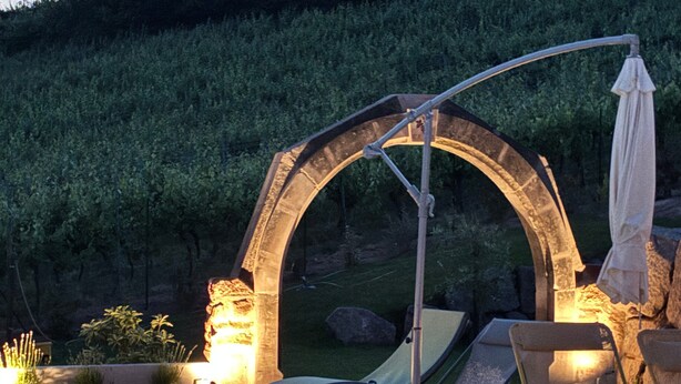 Een buitenzwembad met ligbedden, een pergola en een tent.
