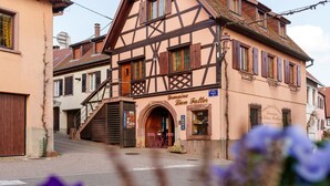 Un edificio tradizionale con struttura a graticcio e un cartello con la scritta 'Domaine Leon Faller'.