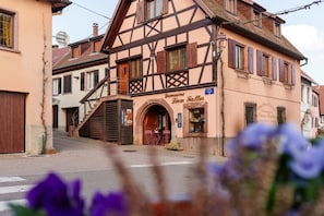 Ein traditionelles Fachwerkhäuschen mit einem Schild, auf dem 'Domaine Leon Faller' steht.