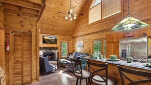 L’intérieur d’une cabane en rondins comprend un coin repas, une cuisine et un salon.