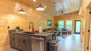 Une cuisine moderne avec des murs en bois, un îlot central et un coin repas comprenant un canapé et des chaises.