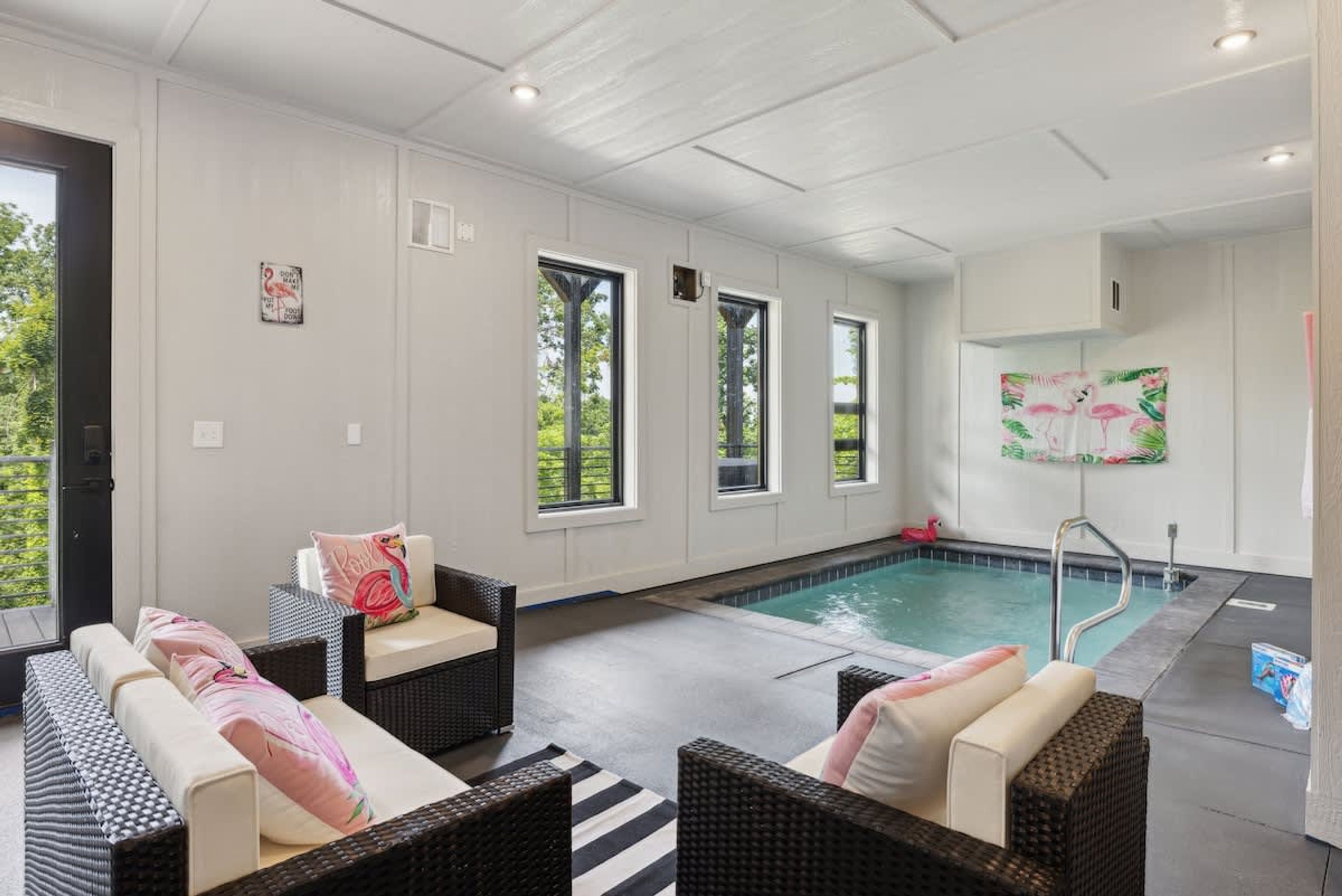 Zona junto a la piscina con mobiliario de mimbre y una piscina.